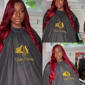 Femme avec une perruque longue ondulée rouge bordeaux, pose de lace frontale naturelle et professionnelle.