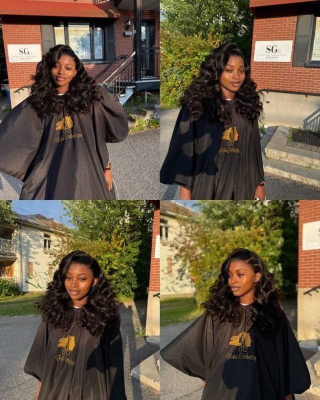 Une jeune femme souriante après une pose de perruque bouclée avec raie sur le côté et baby hair.